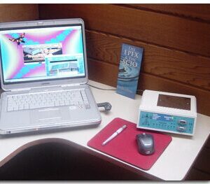 Laptop and device on a wooden desk.